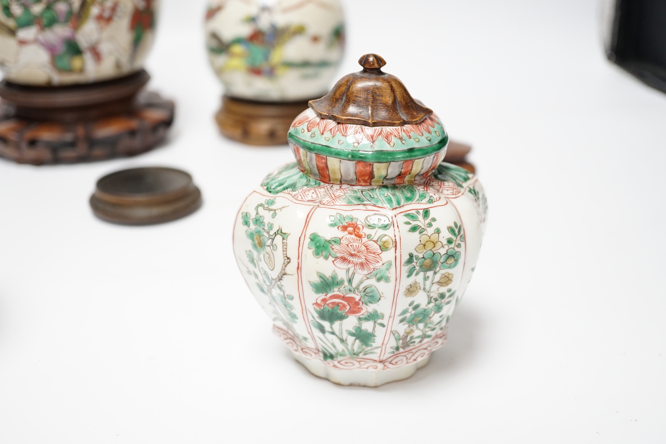 A Chinese famille verte vase, Kangxi period (cut down) and three Chinese polychrome jars with hardwood stands, tallest 19cm